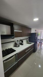 a kitchen with wooden cabinets and a stove top oven at Apto zion in Medellín