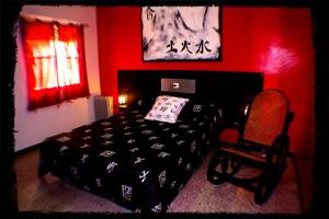 a bedroom with a black bed and a red wall at Pensión El Alamo in Lepe