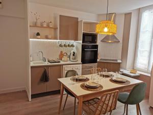 eine Küche mit einem Tisch und Stühlen sowie ein Esszimmer in der Unterkunft Le Zen & Cosy*Hyper centre in Charleville-Mézières