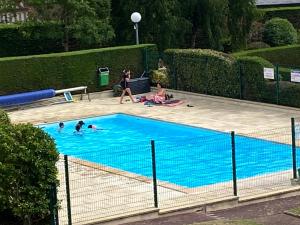 un grupo de personas en una piscina en Picsine, Tennis résidence sévigné 300m mer, en Deauville