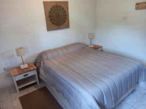 um quarto com uma cama com 2 mesas de cabeceira e 2 candeeiros em Casagrande em Esquel