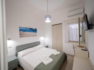 a white bedroom with a bed and a desk at Torre del Salento in Torre San Giovanni Ugento