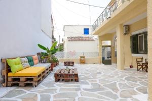 een patio met een bank en tafels in een gebouw bij Feidiou 1, vol I in Aegina Town