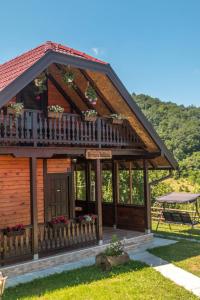 a log cabin with a balcony and a table at Brvnara Sofiana in Bajina Bašta