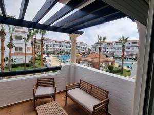 a balcony with two benches and a view of a resort at Appartement pieds dans l’eau à sidi Rahal in Sidi Rahal