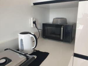 een magnetron naast een koffiezetapparaat bij Sea view luxury Apartment in H̱adera