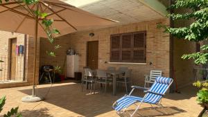 a patio with a table and chairs and an umbrella at La Casa delle Ciliegie in Assisi +46 photos