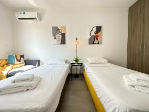 two twin beds in a room with white walls at Vacation mode Apartment in Ayia Napa