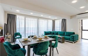 ein Wohnzimmer mit einem blauen Sofa, einem Tisch und Stühlen in der Unterkunft Stunning Apartment In Orebic With Kitchen in Orebić