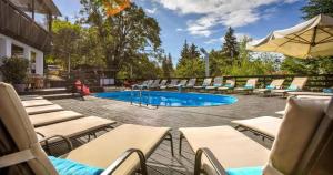 a group of lounge chairs and a swimming pool at Apartament 2711 , proprietate privata in Aparthotel Alpin in Poiana Brasov