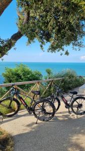 twee fietsen geparkeerd naast een hek bij de oceaan bij B&B Ceresà - Country House in Loreto