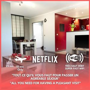 a living room with a red wall at Appartement located at 15 mn from Paris & Orly in Choisy-le-Roi