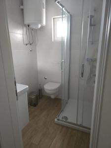 uma casa de banho branca com um chuveiro e um WC. em Apartment Ankica em Crikvenica