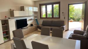 La Casa delle Ciliegie في أسيسي: غرفة معيشة مع طاولة بيضاء وأريكة
