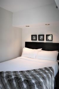 a bedroom with a large white bed with a black headboard at 1BR Resort View at the base of Whistler in Whistler
