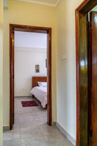 1 dormitorio con 1 cama y puerta grande en Eric and Devota apartments Kampala, en Buwate