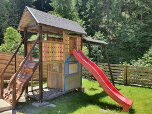 a playground with a slide and a play structure at Casa Sena in Moieciu de Sus