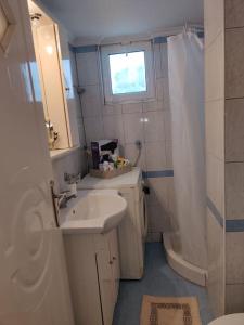 a white bathroom with a sink and a shower at Mixaleas apartments in Kalamata +1 photo