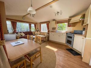 uma cozinha e sala de estar com uma mesa e uma sala de jantar em Brilliant Caravan With Decking And Wifi At Dovercourt Park In Essex Ref 44010a em Great Oakley