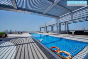 a swimming pool with two life rings in a building at Luxury 1BR Uninterrupted Sea View, Fully Equipped in Ras al Khaimah