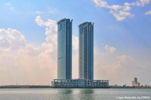 two tall buildings next to a body of water at Luxury 1BR Uninterrupted Sea View, Fully Equipped in Ras al Khaimah