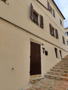 un edificio con una puerta marrón y algunas escaleras en Dolci Soggiorni, en Loreto