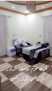 a bedroom with a bed with writing on the floor at فله فاخرة in Tanomah
