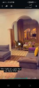 a living room with two couches and a bedroom at فله فاخرة in Tanomah
