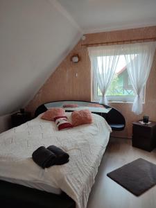 a bedroom with a large bed and a window at Dom Na Mazurach in Przerwanki