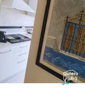 una cocina con una pintura en la pared en Quiero Cádiz, en Cádiz