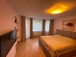 a bedroom with a bed and a flat screen tv at Vila Vanila in Palanga