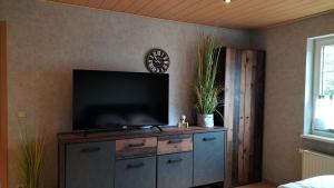 a living room with a flat screen tv on a cabinet at FeWo Weismark in Trier