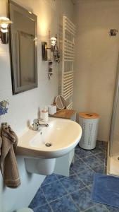 ein Badezimmer mit einem weißen Waschbecken und einem Spiegel in der Unterkunft FeWo Weismark in Trier