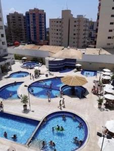 a group of three swimming pools in a building at Apartamento da Gigi Caldas in Caldas Novas