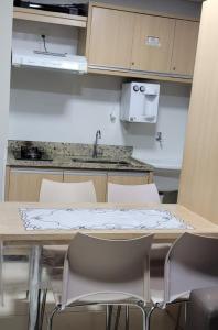a kitchen with a table and chairs and a sink at Apartamento da Gigi Caldas in Caldas Novas