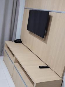 a cabinet with a tv on top of it at Apartamento da Gigi Caldas in Caldas Novas