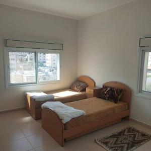 希布倫的住宿－Ain Sara Space，一间卧室设有两张床和窗户。