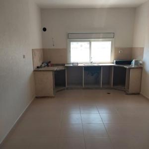 une cuisine vide avec comptoirs et fenêtre dans l'établissement Ain Sara Space, à Hébron