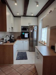 a kitchen with white cabinets and a stainless steel refrigerator at Dom Na Mazurach in Przerwanki