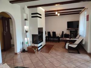 a living room with a fireplace and a table and chairs at Dom Na Mazurach in Przerwanki