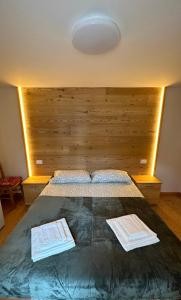 a bedroom with a large bed with a wooden headboard at Casa Felice in Caviola