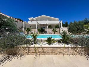 a house with a swimming pool in front of a house at Apartments and Rooms Mateša in Vodice