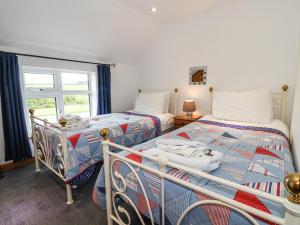 een slaapkamer met 2 bedden en een raam bij The Cottage in Great Driffield