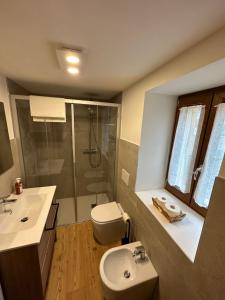 a bathroom with a sink and a shower and a toilet at Casa Felice in Caviola