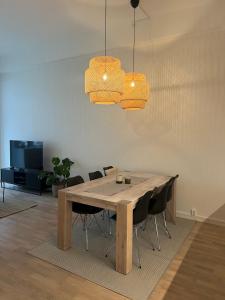 a dining room table with chairs and two lights at Apartment in Breiviken in Bergen