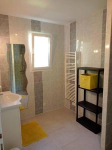 uma casa de banho com um lavatório, um WC e uma janela. em Maison au coeur des vignes em Cussac-Fort-Medoc
