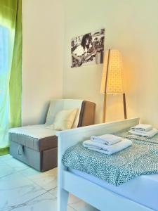 um quarto com uma cama, um candeeiro e uma cadeira em Apartments Mia Patria em Ulcinj