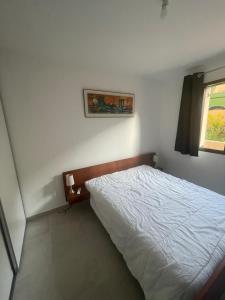 - une chambre avec un lit blanc et une fenêtre dans l'établissement Loue appartement Piana Corse, à Piana