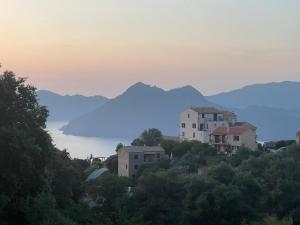 un groupe de maisons sur une colline avec des montagnes en arrière-plan dans l'établissement Loue appartement Piana Corse, à Piana