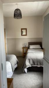 um quarto com 2 camas individuais e um candeeiro em Nanny Goat Rest At Ashlands Farm em Abbots Bromley